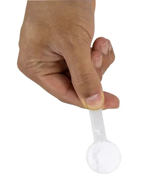 Mão segurando a medida dosadora cheia de creatina em pó