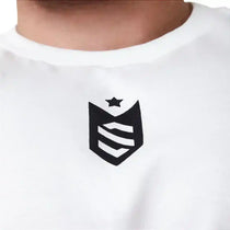 Detalhe de camiseta branca com estampa de brasão preto e estrela, moda fitness